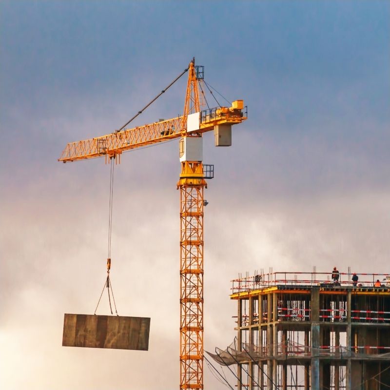 a crane lifting a huge box on a building site